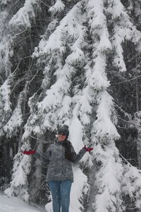 Man standing on snow covered tree