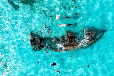 People snorkelling around the ship wreck near cancun in the caribbean sea.