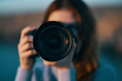 Close-up portrait of woman holding camera