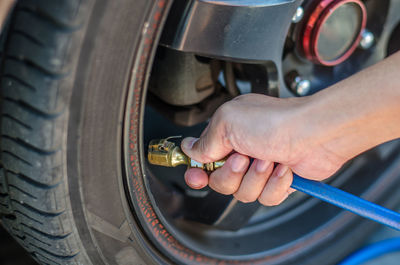 Close-up of person hands inflating car tire