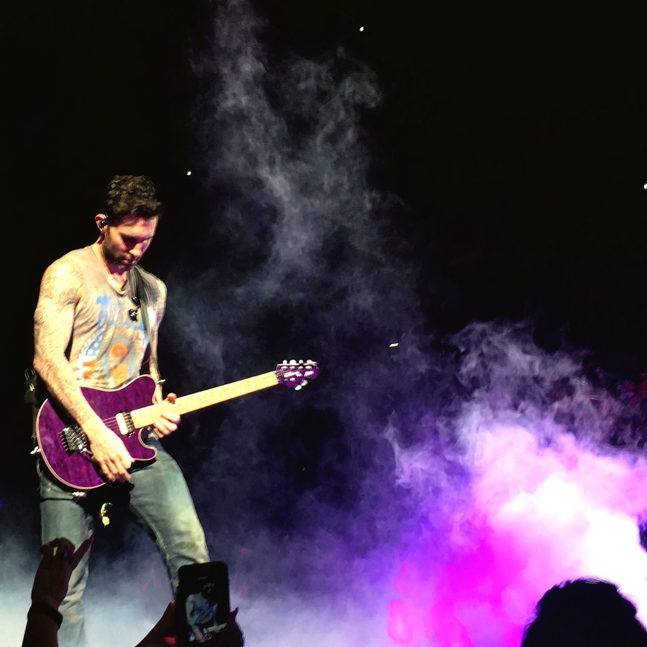 MAN PLAYING GUITAR AT MUSIC FESTIVAL