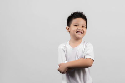 Smiling boy standing against white background