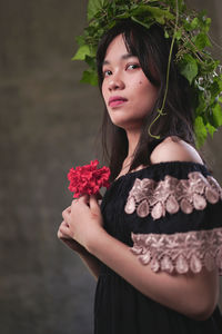 Beautiful young woman holding red flower