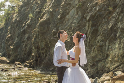 Young couple embracing while standing at beach