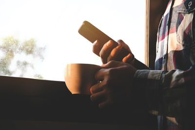 Midsection of man using mobile phone