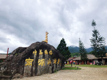 View of text on building against cloudy sky