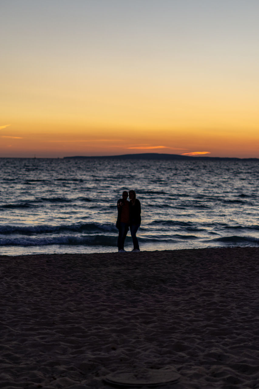 COUPLE ON BEACH DURING SUNSET