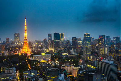 Illuminated buildings in city against sky