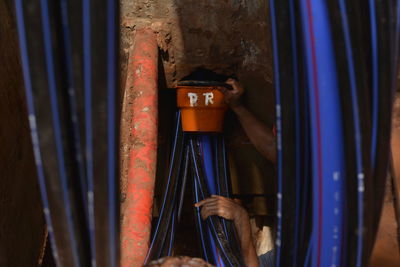 Cropped hand of man holding machine part