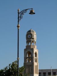 Low angle view of street light by building against sky