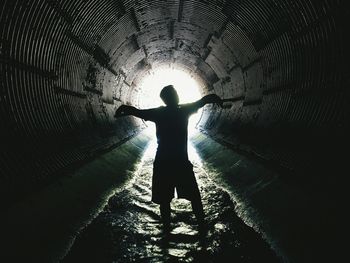 Silhouette man standing in tunnel