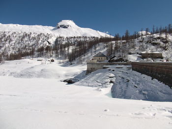 Snow covered landscape against sky