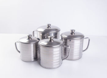 Close-up of steel cooking pots on white background