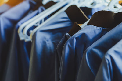 Stylish blue clothes hangers and beautiful blue shirts hang together.