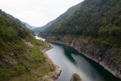 High angle view of river amidst mountains against sky