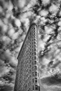 Low angle view of modern building against cloudy sky