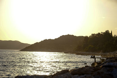 Scenic view of sea and mountains against clear sky