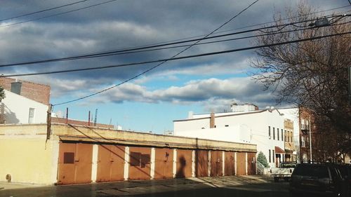 Low angle view of buildings against cloudy sky