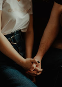 Midsection of couple holding hands