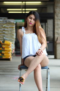 Portrait of young woman sitting on chair indoors