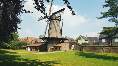 Traditional windmill on field against sky