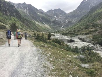 People walking on road against mountain range