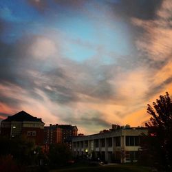 Buildings against cloudy sky at sunset