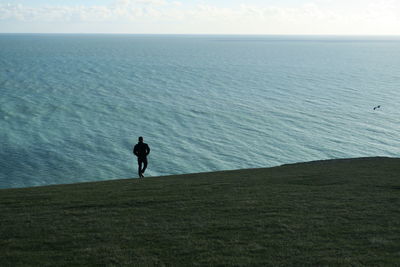 Man standing on beach against clear sky