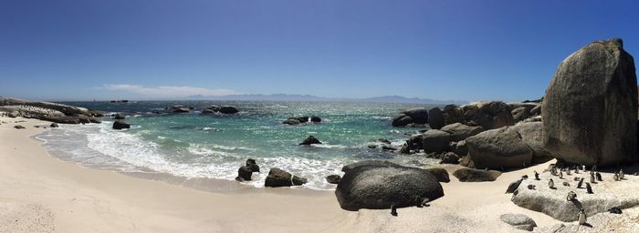 Panoramic view of beach against clear blue sky