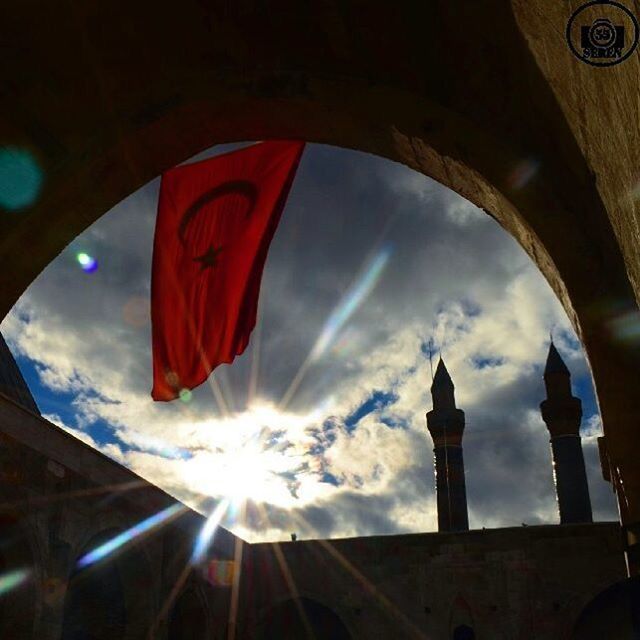 low angle view, architecture, built structure, building exterior, sun, sky, sunbeam, cloud - sky, sunlight, lens flare, cloud, high section, religion, no people, outdoors, day, spirituality, place of worship, tower, city