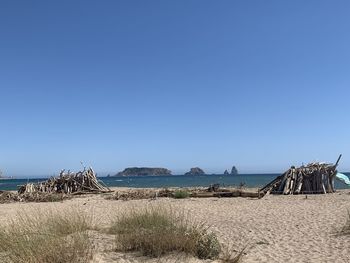 Scenic view of beach against clear blue sky