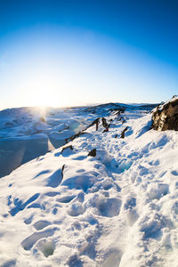 Scenic view of snow covered landscape against blue sky