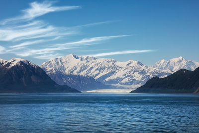 Scenic view of sea and snowcapped mountains against sky