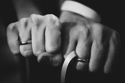 Cropped hands of couple showing engagement rings