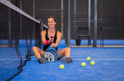 Portrait of beautiful woman playing padel tennis court indoor