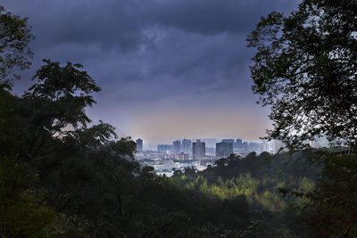 Buildings in city against cloudy sky