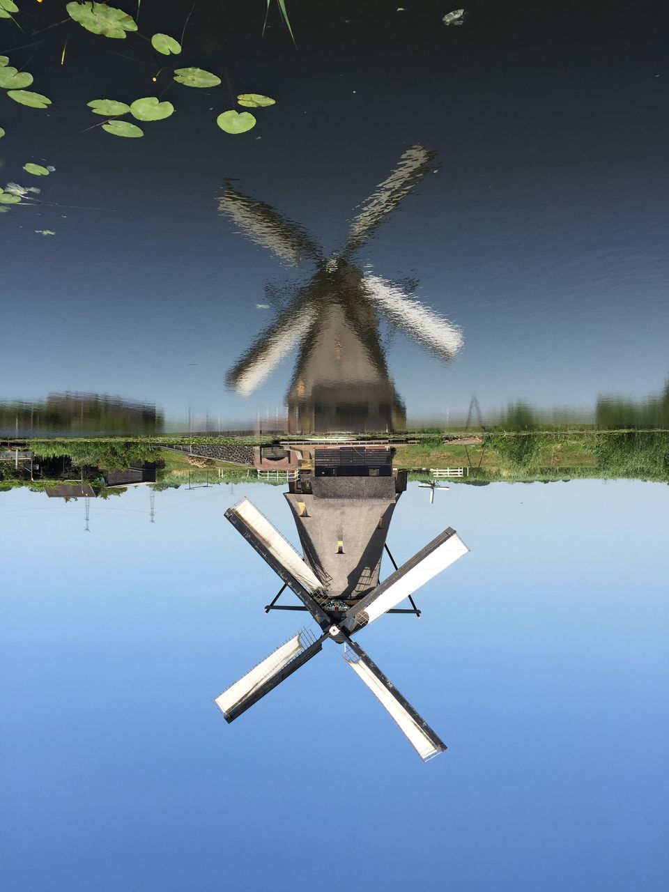 water, lake, wind power, sky, clear sky, windmill, reflection, blue, flying, waterfront, alternative energy, traditional windmill, renewable energy, environmental conservation, travel, river, outdoors, tree, wind turbine, transportation