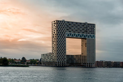 Modern buildings in city against sky during sunset