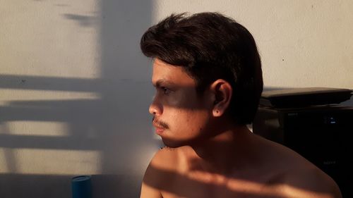 Portrait of young man looking away at home