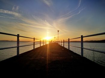 Bridge over sea against sky during sunset