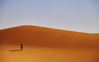 Man standing on desert against clear sky