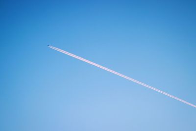 Low angle view of vapor trail in blue sky