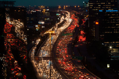 High angle view of illuminated road amidst buildings at night