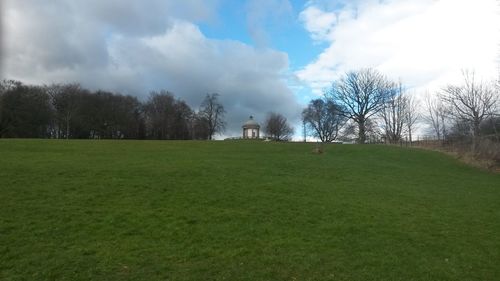 Scenic view of grassy field against cloudy sky