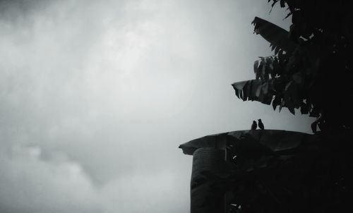 Low angle view of silhouette statue against sky