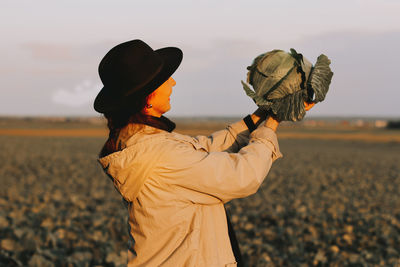 Woman picking cabbage vegetable at field.female farmer working at organic farm. harvesting at autumn