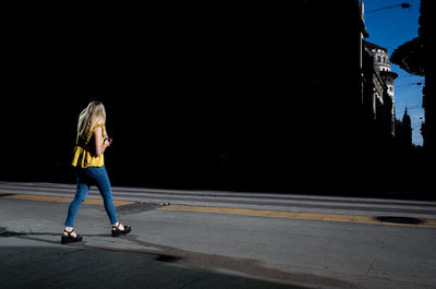 Woman with umbrella standing on road