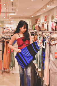 Young woman buying clothes in shopping mall