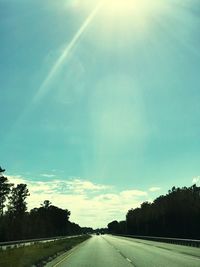 Road amidst trees against sky