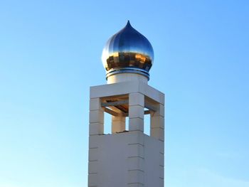 Low angle view of bell tower against blue sky